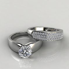 two white gold wedding rings with diamonds on the sides and an engagement ring in the middle