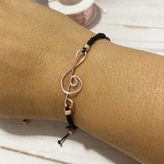 "This special and delicate Treble Clef Bracelet is a perfect gift for someone who loves music. As this is one of the most recognizable symbols in music it will be a very good way to shoe the world that you are a music lover.  It comes with a treble clef connector charm handmade of gold plated wire, on a macrame knotted nylon cord band and a very cute gold beads at the end of the adjustable strings.   I T E M ~D E T A I L S Materials: nylon and gold or silver plated wire charm and beads. Length: Adjustable Symbolic Bracelets As Gift, Symbolic Adjustable Bracelets As Gift, Adjustable Metal Bracelet As A Gift For Her, Adjustable Metal Bracelets As A Gift For Her, Adjustable Friendship Bracelets Gift, Metal Band Jewelry As Gift, Symbolic Adjustable Charm Bracelet As Gift, Adjustable Rose Gold Bracelet As A Gift, Adjustable Rose Gold Bracelet Perfect As A Gift