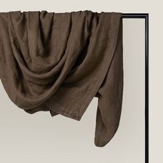 an open window with a brown cloth hanging from it's side and the curtain partially closed