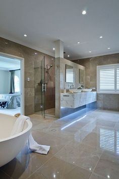 a large bathroom with marble flooring and white bathtub next to a walk in shower