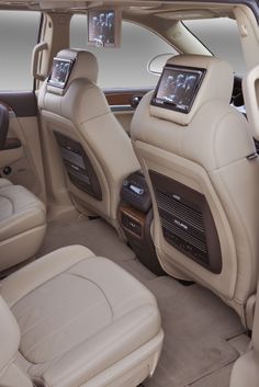 the interior of a luxury car with beige leather seats and electronic controls on the dashboard