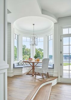 a dining room with white walls and wood floors