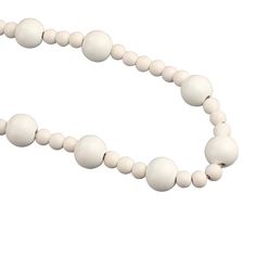 a white beaded necklace on a white background