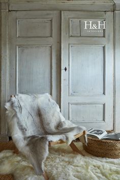 a white cow hide sitting on top of a rug next to a basket and door