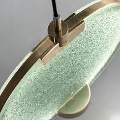 a close up of a light fixture on a gray surface with a black cord hanging from it