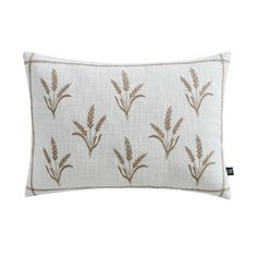 a white pillow with brown flowers on the front and side, sitting on a white background