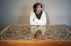 a woman sitting at a table with her arms crossed