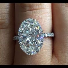 a close up of a person's hand with a diamond ring