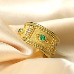 Elevate your style with our captivating gold ring, adorned with mesmerizing round emeralds and shimmering brilliance. Intricately crafted golden details, such as delicate granulations surrounding the emeralds and rows of diamonds nestled between them, add a touch of exquisite elegance. Radiating timeless beauty and sophistication, this ring is a stunning statement piece that effortlessly enhances any ensemble. 100% handmade in our workshop. Metal: 14K Gold| 18K Gold Gemstones: Emerald | weight 0 Luxury Gold Emerald Ring, Luxury Gold Emerald Round Ring, Luxury Gold Emerald Ring For Promise, Luxury Gold Emerald Promise Ring, Luxury Gold Emerald Ring For Wedding, Luxury Gold Emerald Ring For Formal Occasions, Exquisite Gold Emerald Ring With Diamond, Luxury Gold Emerald Ring For May Birthstone, Gold Diamond Emerald Ring Fine Jewelry