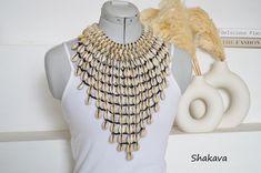 African inspired cowrie sea shell necklace bib design, unique and trendy. PRODUCT SPECIFICATIONS: Necklace length - 48.0 cm. Length downwards - 26.0 cm. Closure - brass hook Materials - beads, cowrie shells ADDITIONAL INFORMATION New and unworn: Yes Handmade in Kenya: Yes Other jewelry in my shop: https://www.etsy.com/shop/shakava Bib Design, Cowrie Shell Necklace, Necklace African, Cowrie Shells, Brass Hook, Seashell Necklace, African Jewelry, Shell Necklace, Cowrie Shell