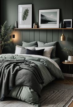 a bed with green sheets and pillows in a bedroom next to two framed pictures on the wall