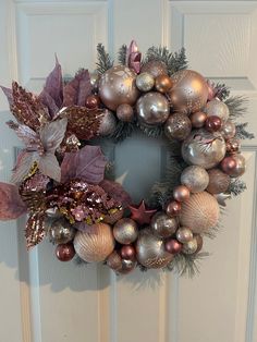 a wreath with ornaments hanging on the front door