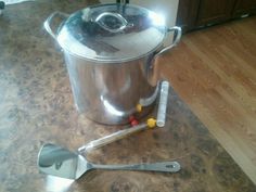 a stainless steel pot with tongs and measuring spoon