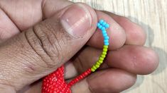 a person is holding a small beaded string