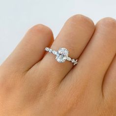 a woman's hand with a diamond ring on top of her finger and an engagement band