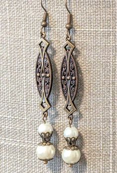 Gorgeous handcrafted vintage style earrings, perfect for a bride!! Created using antique brass links with Art Nouveau and Art Deco motifs, ear wires and intricate filigree bead caps and two sizes of lustrous, creamy ivory glass pearls!!  Length 3" Bronze Antique Finish Dangle Earrings, Vintage French Hook Earrings For Wedding, Vintage Wedding Earrings With French Hook, Vintage Brass Chandelier Earrings For Wedding, Victorian Wedding Earrings With Antique Finish, Elegant Bronze Brass Chandelier Earrings, Ornate Nickel-free Chandelier Earrings For Wedding, Vintage Brass Filigree Chandelier Earrings, Vintage Bronze Chandelier Earrings In Brass