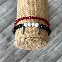 This is a great spooky bracelet pair.  They are perfect for Halloween! 🩸Handmade 🩸Custom Sizing 🩸Made to Order They are made with: 🩸Round black ball beads 🩸Round white ball beads 🩸Pointy hematite beads 🩸Transparent round red beads 🩸Stretchy cord for easy wear Free shipping on all orders! Gothic Bracelets For Halloween Gift, Gothic Halloween Bracelets As A Gift, Gothic Halloween Bracelets Gift, Adjustable Vampire Jewelry For Halloween, Adjustable Gothic Wristband For Gift, Gothic Adjustable Bracelets For Halloween, Gothic Wristband Bracelet Gift, Red Beaded Bracelets For Halloween Gift, Adjustable Punk Beaded Bracelets As Gift