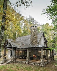 a log cabin with a stone chimney in the woods