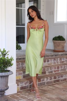 a woman in a green dress standing on steps