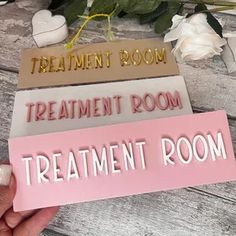 someone holding up some signs that say treatment room, treatment room, and treatment room