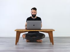 a man sitting on the floor with his laptop in front of him and looking at the screen