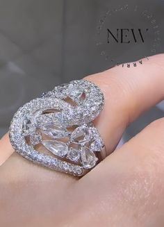 a woman's hand with a diamond ring on top of her finger and the words new written below it