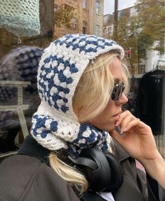 a woman wearing a hat and scarf talking on her cell phone