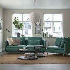 a living room with two couches and a coffee table in front of large windows