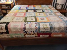 a bed with a quilt on top of it in a room next to a lamp