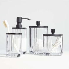 three bathroom accessories including soap dispenser, toothbrush holder and glass container