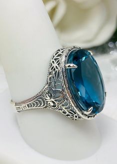 Natural London Blue Topaz Ring Description Persian Design#230 Made-Custom This is a brand new stunning Art Deco/Vintage designed sterling silver filigree 18ct oval Natural/Genuine London Blue Topaz ring. The oval full cut high-quality VS to VVS Topaz is 18mm (just shy of 3/4th of an inch) by 13mm (1/2 inch) in dimension... This ring is 21mm NS on the finger. The inside of the band is marked 925 for sterling. Notice the beautiful filigree swirl like the craftsmanship of the silver setting. This l Luxury Modern Silver Topaz Ring, Elegant Luxury Large Stone Topaz Ring, Luxury Faceted Silver Topaz Ring, Luxury Large Stone Topaz Ring For Anniversary, Exquisite Luxury Topaz Rings, Vintage Luxury Topaz Ring Collectible, Vintage Luxury Topaz Collectible Ring, Luxury Antique Topaz Gemstone Ring, Luxury Antique Topaz Jewelry