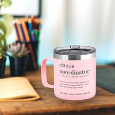 a pink coffee mug sitting on top of a wooden table