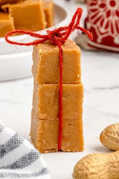 three pieces of peanut butter fudge next to peanuts