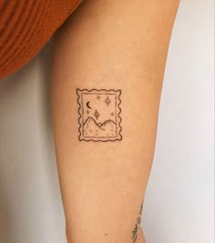 a small postage stamp tattoo on the right arm, with stars and moon in it