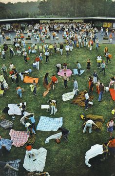 a large group of people standing around in the grass