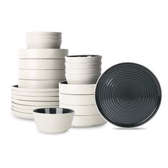 a stack of white and black dishes on a white background