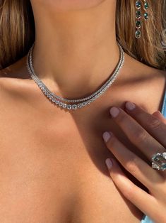 Our modern interpretation of the classic tennis necklace features 116 graduating diamonds, handcrafted in 18K white gold. With approximately 14.50 carats of round brilliant cut diamonds, the subtle graduated stone setting gives just a hint of unconventional charm and intrigue. This heirloom-worthy piece lays flush against the neck, adding refined elegance to any neckline. Diamond Tennis Necklace, Tennis Necklace, Stone Setting, Brilliant Diamond, Metal Necklaces, Round Brilliant Cut Diamond, Stone Settings, Brilliant Cut Diamond, White Gold Diamonds