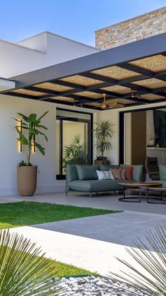 an outdoor living area with couches and potted plants