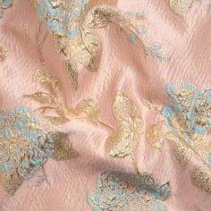 a pink and blue fabric with gold flowers on it