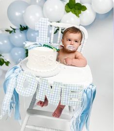 a baby is sitting in a chair with a cake