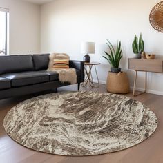 a living room with black leather couches and white rug