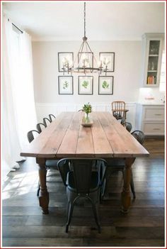 a dining room table with chairs and pictures on the wall