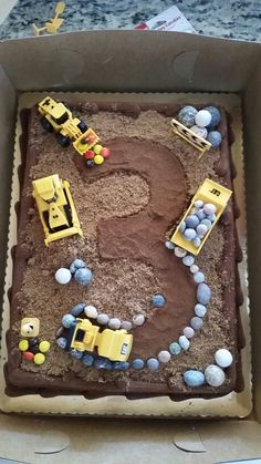 a birthday cake in the shape of a number eight with construction vehicles and rocks on it