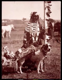 an old photo of a native american man and his dog with other animals in the background