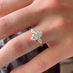 a close up of a person's hand with a diamond ring on their finger