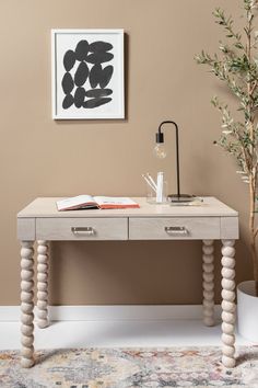 a wooden desk with two drawers and a lamp on the table in front of it