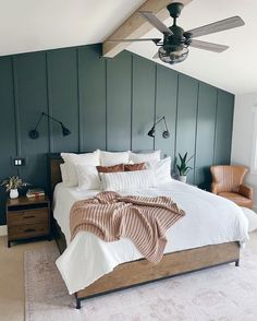 a bedroom with a bed, ceiling fan and two lamps on either side of the bed