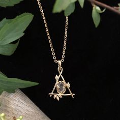 Our Fae Collection was inspired by childhood days spent in the woods talking to the trees and feeling at home with the woodland spirits. Our Fae Necklace is a delicate branch triangle holding a genuine quartz crystal at its center. Brass plated in goldtone. 16" length chain with a 3" extension for adjustable length. Each crystal will be white but with variation of clarity and occlusion due to natural variation in the mineral and no two will be alike. All orders over $50 ship for free within the Feeling At Home, The Fae, Childhood Days, Magical Jewelry, Butterfly Jewelry, Jewelry Lookbook, Jewelry Inspo, Pretty Jewellery, In The Woods