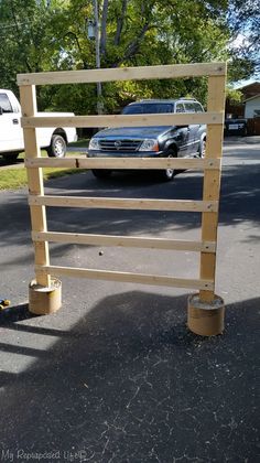 a wooden sign sitting in the middle of a parking lot next to a white truck