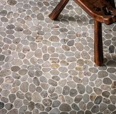 a wooden bench sitting on top of a stone floor